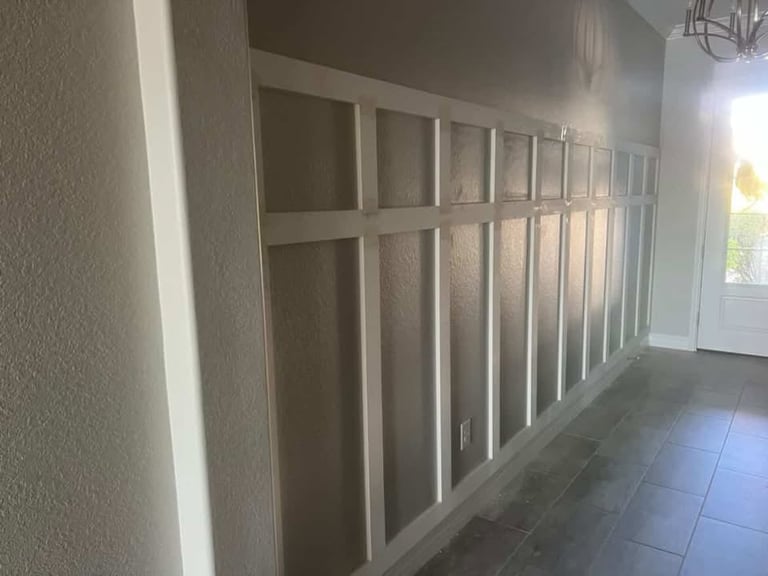 A hallway with white built-in closet doors and sliding glass doors visible in bright daylight