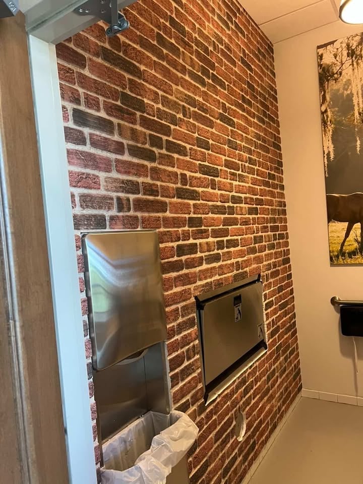 Brick fireplace with metal insert and hearth in modern interior room with warm lighting